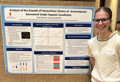 Photo of Evie presenting her first poster from her internship in the lab