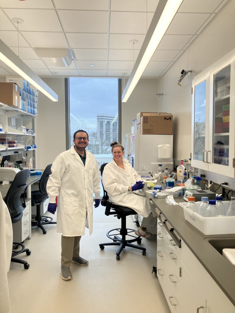 Photo of Varad and Cody with their lab coats on enjoying the new lab space